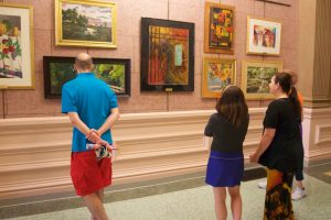 people looking at artwork on a wall